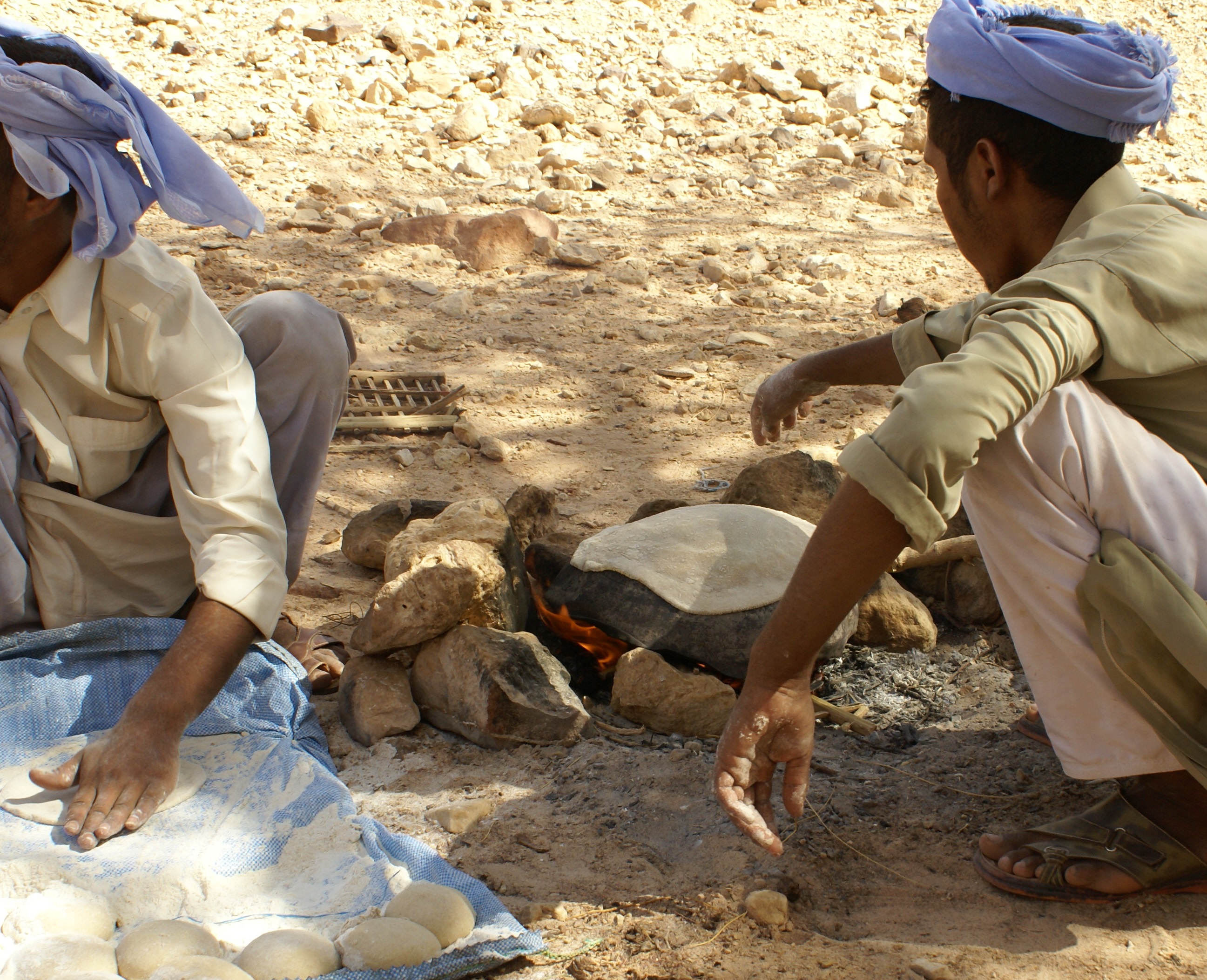 上图：贝都因人（Bedouin）至今还在沿用古代的方法，在炭火烧热的石头上烤饼。